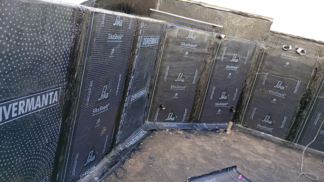 Finalização do serviço de impermeabilização em uma piscina de alvenaria antes do revestimento.